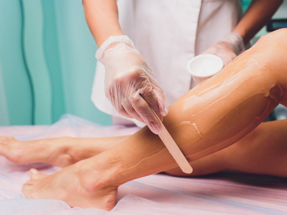 Applying a contact gel before the procedure of laser hair removal. Application of sugar paste for the procedure of shugaring.